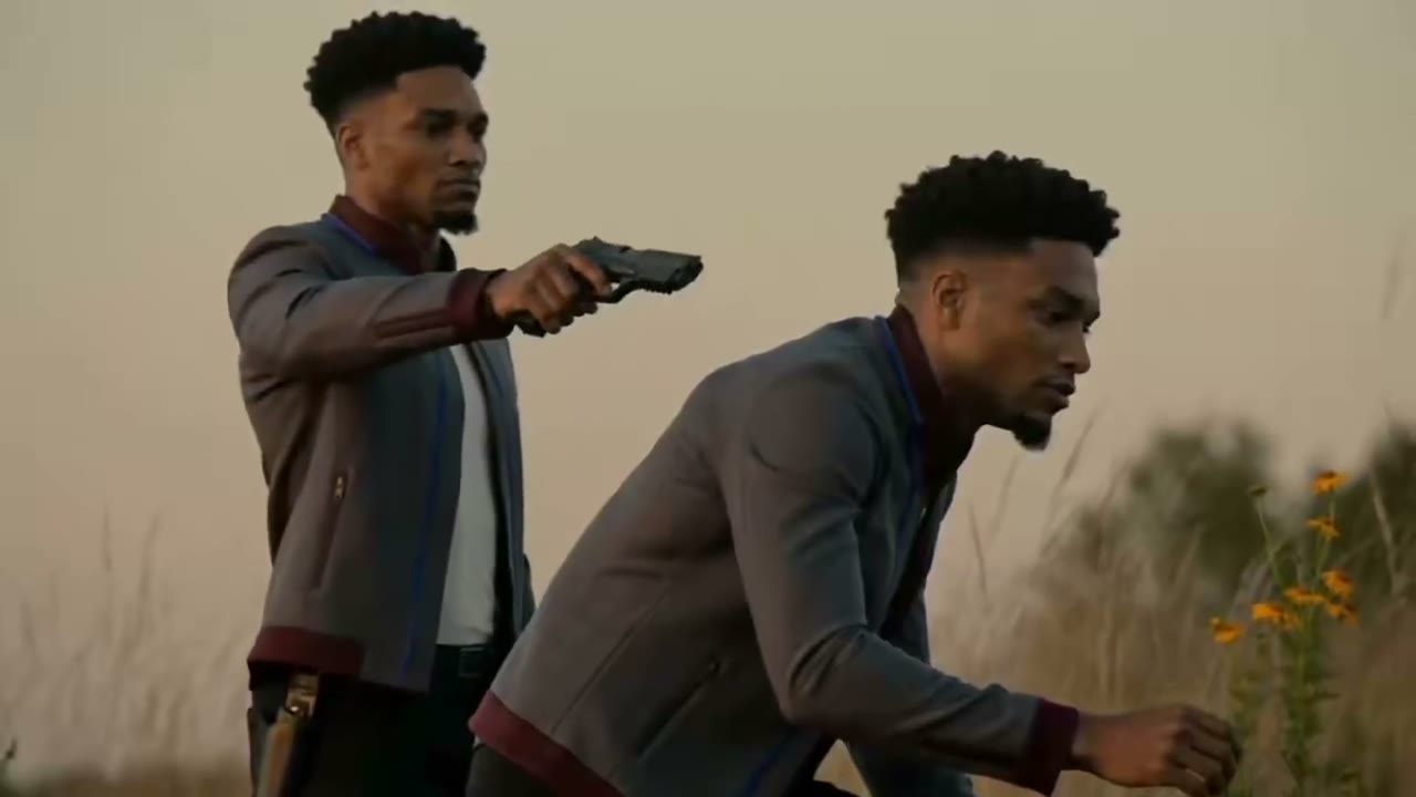 Two duplicates of the same man in a field at dusk